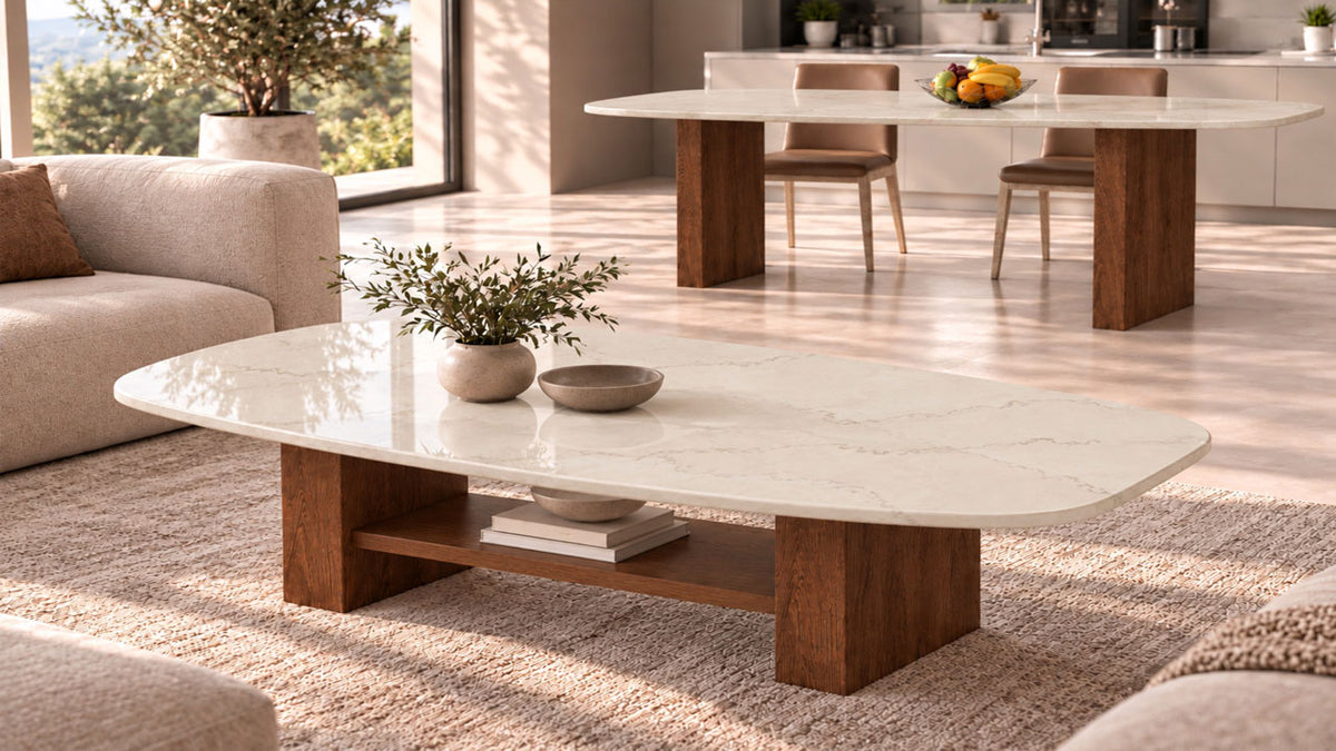 Couchtisch nach Maß mit heller Steinplatte in mediterranem Beige und passendem Esstisch im Hintergrund. Beide Tische mit Säulengestellen aus Holz